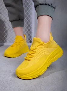 Details von gelben Strick-Wanderschuhen mit atmungsaktivem Stoff und Wellensohle