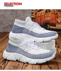 Dettaglio della tomaia in tessuto fly-knit bianco e blu su scarpe sportive con suola spessa
