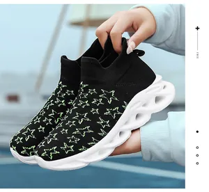 Dettaglio sneaker in maglia nera con stelle neon e suola bianca con design a onde