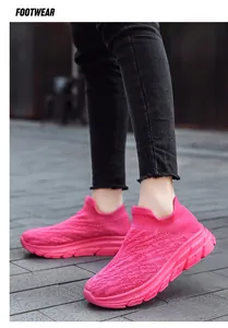 Macro side view of breathable rose red knitted walking sneakers with thick cushioned soles