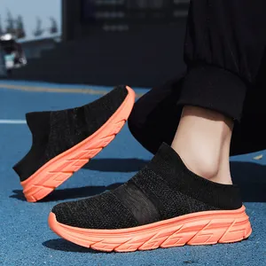 Breathable black knit slip-on mule sneakers with vibrant orange thick rubber soles