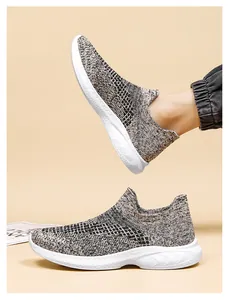Detail of breathable fly-knit slip-on sneakers with textured gray weave and white sole