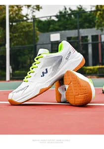 Detail van lichte sportschoenen met wit bovenwerk, groene veters en rubberen buitenzolen