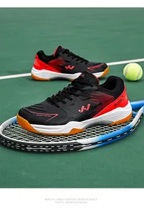 Detailweergave van ademende rood-zwarte tennisschoenen op een tennisbaan met een racket