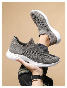 Detail of grey fly-knit walking shoe showing textured mesh fabric and thick white sole