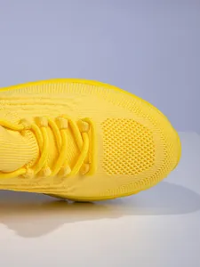 Detailansicht des hellgelben Strickobermaterials und der Schnürsenkel der Wanderschuhe