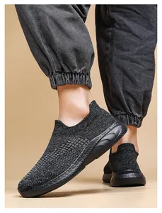 Close-up of black breathable fly-knit mesh fabric and thick wavy sole on walking shoes