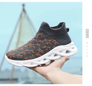 Dettaglio scarpa a calzino in maglia grigio scuro con stelle arancioni e suola scavata