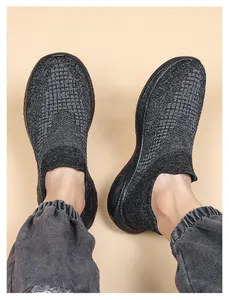 Top-down view of dark grey knitted sock sneakers with thick black soles and elastic cuffs