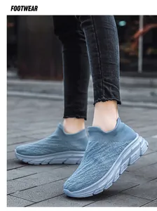 Detail of navy knit slip-on sneakers with breathable mesh texture and thick gray soles