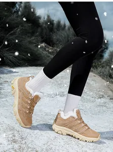 Detail von khakifarbenen Wanderschuhen mit Kunstfellfutter im Schnee für Outdoor-Wärme