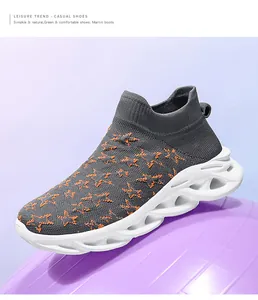Dettaglio di sneaker in maglia grigio scuro con stelle arancioni e suola ondulata cava