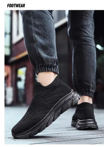 Close-up of black breathable fly-woven slip-on sneakers for men on a street walk