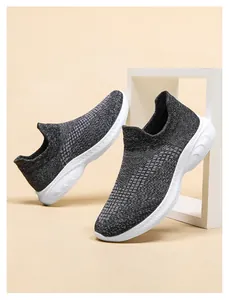 Detailed close-up of dark grey breathable fly-woven knit fabric and lightweight white EVA sole