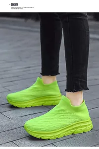 Close-up of neon green knitted slip-on walking shoes for men with thick outsole