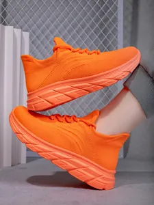 Seitenansicht der leuchtend orangefarbenen Wanderschuhe mit dicker gewellter Sohle