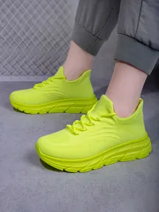 Detailansicht neongrüner atmungsaktiver Strick-Wanderschuhe mit dicker Dämpfungssohle
