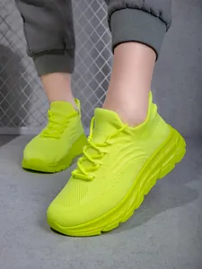 Nahaufnahme neongrüner atmungsaktiver Mesh-Wanderschuhe mit dicker Sohle für Outdoor-Sport