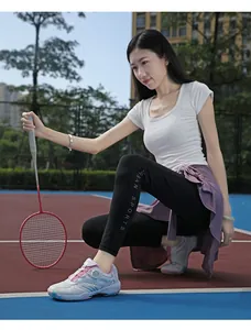 Detail of pink badminton shoes with rotary dial lacing and black high-stretch pants