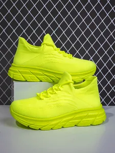Detail des neongelben Strickmaterials und der rutschfesten Sohle der Outdoor-Sneaker