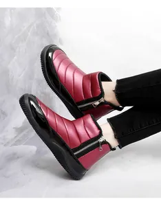 Detail of burgundy quilted snow boot featuring side zipper and thick non-slip rubber sole