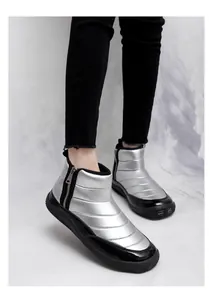 Detail view of silver quilted winter boots with side zipper and thick non-slip black sole