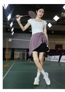 Action shot of women's sports outfit with white top and purple skirt for indoor badminton