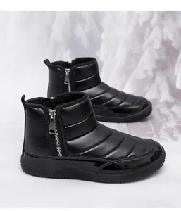 Detail view of black winter snow boots with quilted fabric, side zipper and plush lining