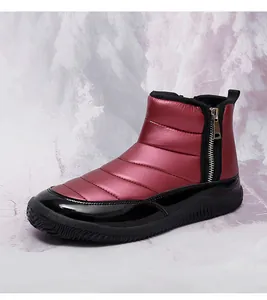 Detail view of wine red quilted snow boots with side zipper and thick non-slip soles