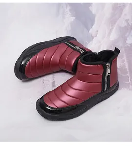 Detail view of burgundy quilted winter boots with waterproof fabric and plush lining