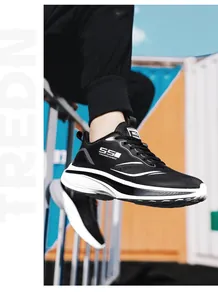 Tragefoto der atmungsaktiven schwarzen Mesh-Laufschuhe mit weißer Sohle und Modestreifen