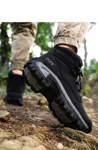 Detail showing the deep non-slip rubber sole treads of black outdoor hiking boots