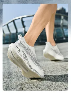 Primer plano de zapatilla deportiva de malla gris y blanca con suela de patrón de llama
