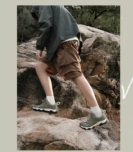 Gros plan de chaussures de randonnée légères vert olive pour hommes sur terrain rocheux