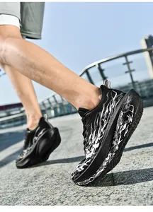 Detalle de zapatilla deportiva negra con patrón de llamas blancas y suela gruesa cómoda