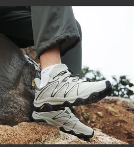 Outdoor hiking shoes with quick-lace system and thick rubber sole on natural rocks
