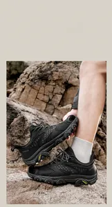 Détail de chaussure de randonnée noire avec mesh synthétique sur terrain rocheux