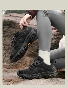 Détail de chaussures de randonnée noires avec semelles antidérapantes sur terrain rocheux