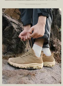 Gros plan de chaussures de randonnée kaki avec semelles en caoutchouc sur rochers