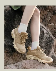 Détail d'une chaussure de randonnée kaki avec semelle en caoutchouc durable sur un rocher