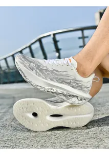 Detalle de zapatillas de running en malla blanca con textura de llamas grises y suela gruesa