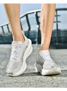 Primer plano de zapatillas de malla transpirable con logo naranja y suela gruesa