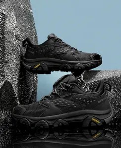 Détails de chaussures de randonnée noires avec semelles crantées en caoutchouc sur roche