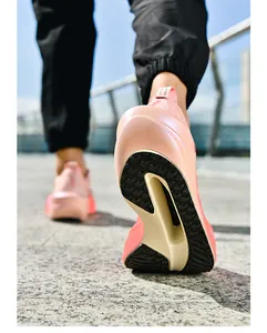 Detail of pink-orange breathable mesh running shoe featuring a hollow cushioned thick sole