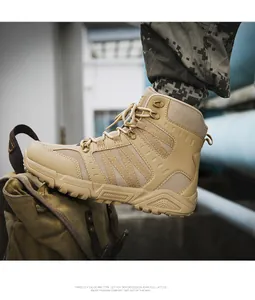 Close-up of sand-colored tactical boots with rubber soles on a green canvas bag