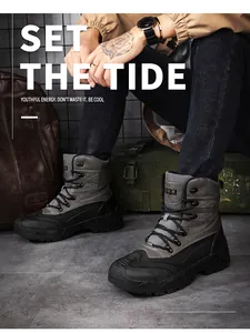 Detail of mid-cut tactical boots with grey suede panels and deep-grooved rubber sole