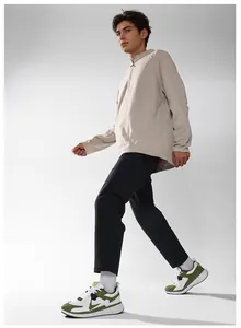 Men's stylish athletic outfit featuring color-blocked sneakers and track jacket on gray background