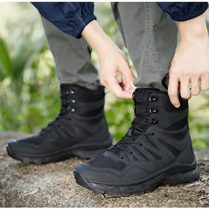 Close-up of black tactical hiking boots featuring breathable mesh and thick rubber soles