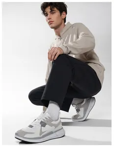 Detail of classic men's white and grey patchwork sneakers with comfortable thick sole