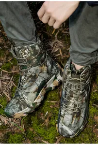 Detail of woodland camouflage tactical boots with thick anti-slip rubber soles outdoors